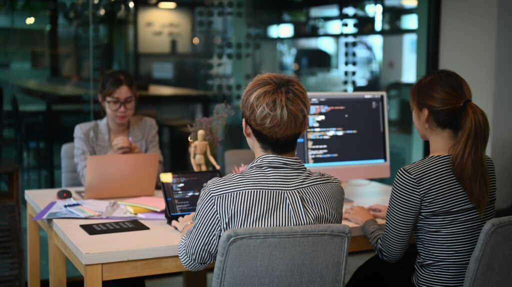 Software developers team brainstorming and programming in co working space.
