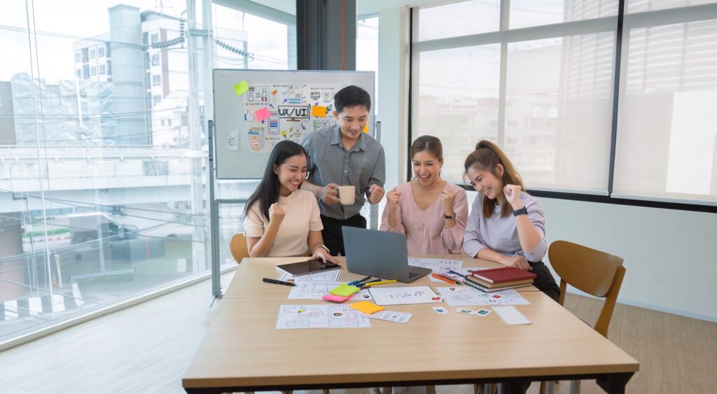 ux developers and ui designers and Asian business people are enjoying their startup business.